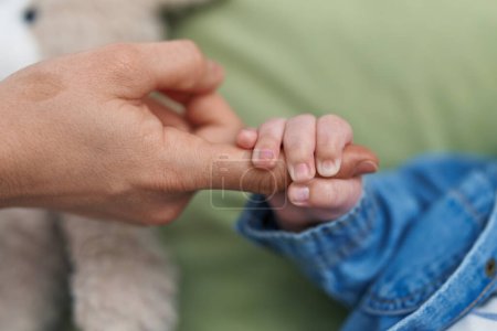 Photo for Adorable caucasian baby holding mother finger at bedroom - Royalty Free Image