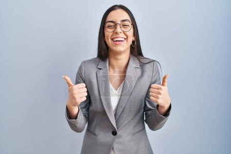 Photo for Hispanic business woman wearing glasses success sign doing positive gesture with hand, thumbs up smiling and happy. cheerful expression and winner gesture. - Royalty Free Image