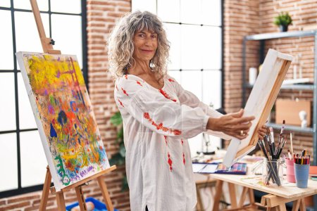 Foto de Mujer de mediana edad artista buscando dibujo en el estudio de arte - Imagen libre de derechos