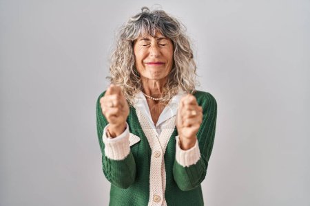 Téléchargez les photos : Middle age woman standing over white background excited for success with arms raised and eyes closed celebrating victory smiling. winner concept. - en image libre de droit