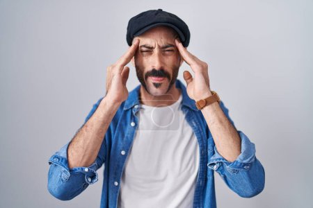 Téléchargez les photos : Homme hispanique avec la barbe debout sur fond isolé avec la main sur la tête, maux de tête parce que le stress. migraine souffrant. - en image libre de droit