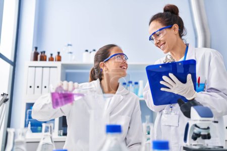 Téléchargez les photos : Femme et fille portant l'uniforme de scientifique travaillant au laboratoire - en image libre de droit