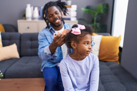 Téléchargez les photos : Père et fille souriant confiant peigner les cheveux à la maison - en image libre de droit