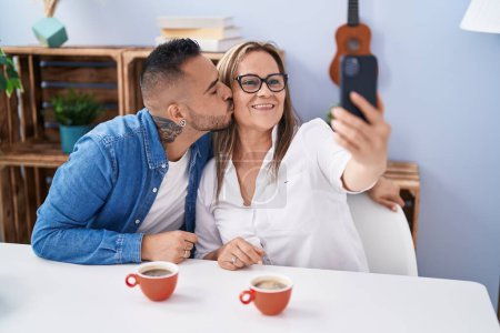 Téléchargez les photos : Homme et femme mère et fils boire du café faire selfie par smartphone à la maison - en image libre de droit