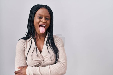 Photo for African woman with braids standing over white background sticking tongue out happy with funny expression. emotion concept. - Royalty Free Image