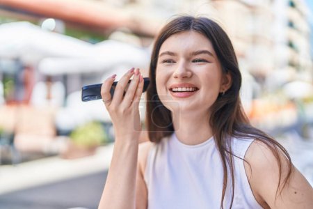 Photo for Young caucasian woman smiling confident listening audio message by the smartphone at street - Royalty Free Image