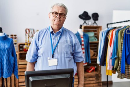 Photo for Senior man with grey hair working as manager at retail boutique relaxed with serious expression on face. simple and natural looking at the camera. - Royalty Free Image