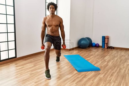 Photo for Young african american man training using dumbbells at gym - Royalty Free Image