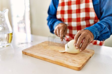 Photo for Senior man cutting onion at kitchen - Royalty Free Image