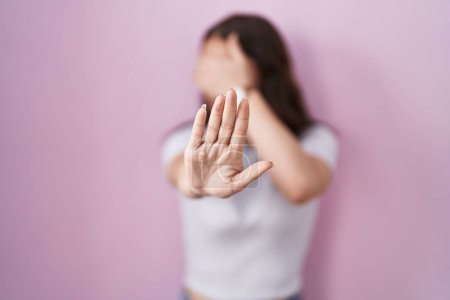 Photo for Young hispanic girl standing over pink background covering eyes with hands and doing stop gesture with sad and fear expression. embarrassed and negative concept. - Royalty Free Image