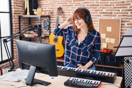 Téléchargez les photos : Young woman musician playing piano keyboard at music studio - en image libre de droit