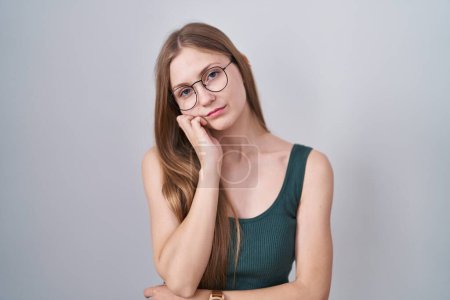Foto de Young caucasian woman standing over white background thinking looking tired and bored with depression problems with crossed arms. - Imagen libre de derechos