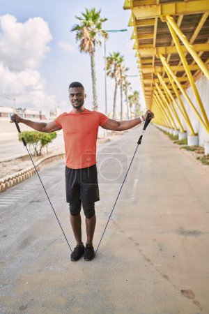 Téléchargez les photos : Jeune homme afro-américain portant des vêtements de sport formation à la rue - en image libre de droit