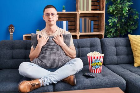 Photo for Young man eating popcorn skeptic and nervous, frowning upset because of problem. negative person. - Royalty Free Image