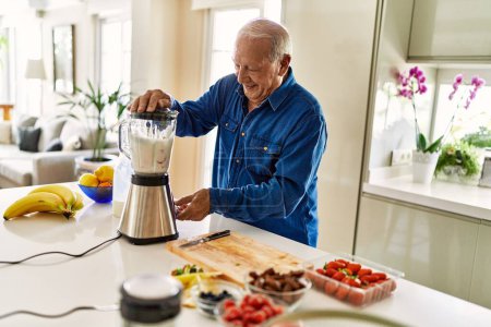 Photo for Senior man smiling confident shaking blender at kitchen - Royalty Free Image