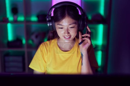 Téléchargez les photos : Femme chinoise streamer souriant confiant en utilisant l'ordinateur à la salle de jeu - en image libre de droit