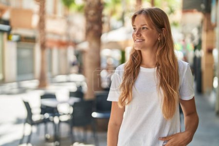 Photo for Young blonde girl smiling confident looking to the side at street - Royalty Free Image