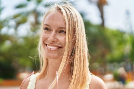 Photo for Young blonde woman smiling confident looking to the side at park - Royalty Free Image