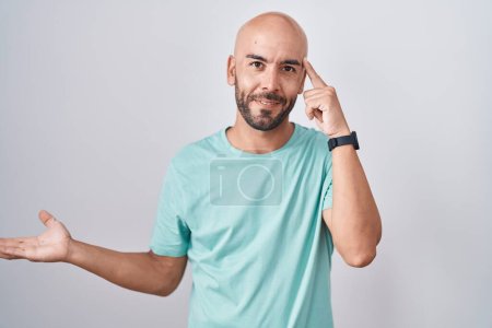 Photo for Middle age bald man standing over white background confused and annoyed with open palm showing copy space and pointing finger to forehead. think about it. - Royalty Free Image