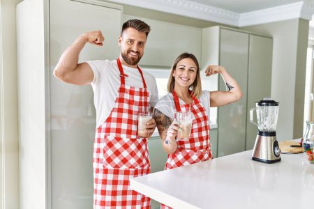 Téléchargez les photos : Jeune couple faisant un geste fort tenant un verre de smoothie à la cuisine - en image libre de droit