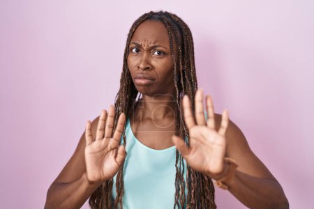Photo for African american woman standing over pink background moving away hands palms showing refusal and denial with afraid and disgusting expression. stop and forbidden. - Royalty Free Image