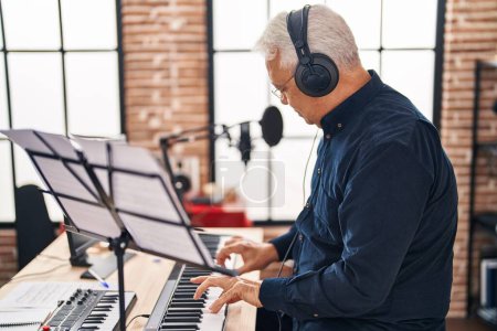 Téléchargez les photos : Senior man musician playing piano keyboard at music studio - en image libre de droit