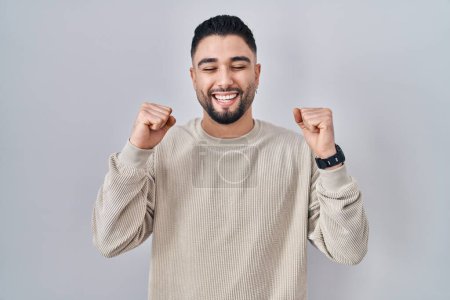 Photo for Young handsome man standing over isolated background excited for success with arms raised and eyes closed celebrating victory smiling. winner concept. - Royalty Free Image