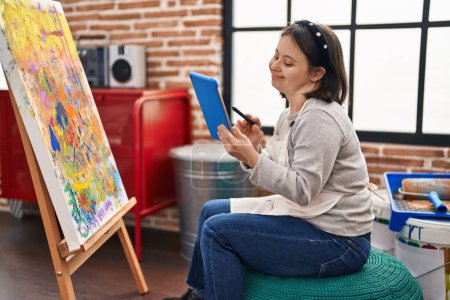 Foto de Mujer joven con síndrome de Down artista dibujo en touchpad en el estudio de arte - Imagen libre de derechos