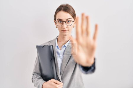 Photo for Young caucasian woman wearing business clothes and glasses doing stop sing with palm of the hand. warning expression with negative and serious gesture on the face. - Royalty Free Image