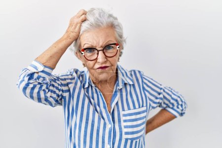 Photo for Senior woman with grey hair standing over white background confuse and wonder about question. uncertain with doubt, thinking with hand on head. pensive concept. - Royalty Free Image