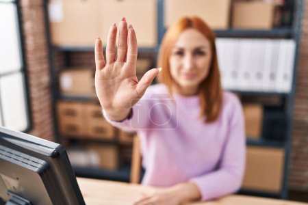 Photo for Young caucasian woman ecommerce business worker doing stop gesture with hand at office - Royalty Free Image