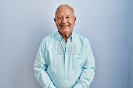 Photo for Senior man with grey hair standing over blue background with a happy and cool smile on face. lucky person. - Royalty Free Image