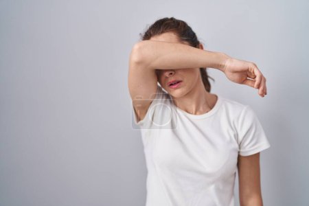 Photo for Beautiful brunette woman standing over isolated background covering eyes with arm, looking serious and sad. sightless, hiding and rejection concept - Royalty Free Image