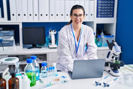 Téléchargez les photos : Jeune femme hispanique scientifique utilisant un ordinateur portable travaillant au laboratoire - en image libre de droit