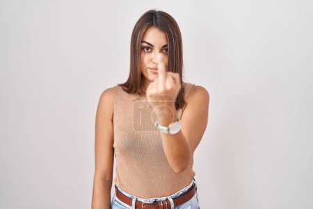 Foto de Young hispanic woman standing over white background showing middle finger, impolite and rude fuck off expression - Imagen libre de derechos