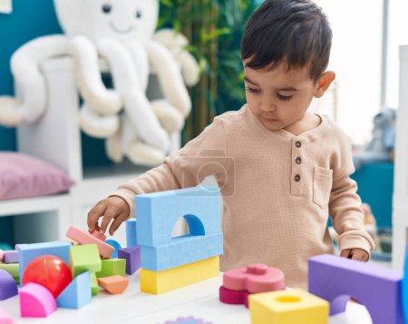 Photo for Adorable hispanic toddler playing with construction blocks standing at home - Royalty Free Image