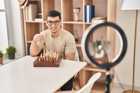 Téléchargez les photos : Jeune homme arabe faisant tutoriel d'échecs souriant heureux pointant avec la main et le doigt - en image libre de droit