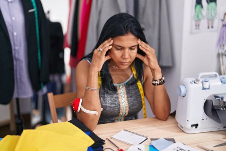 Téléchargez les photos : Middle age hispanic woman tailor stressed sitting on table at tailor shop - en image libre de droit