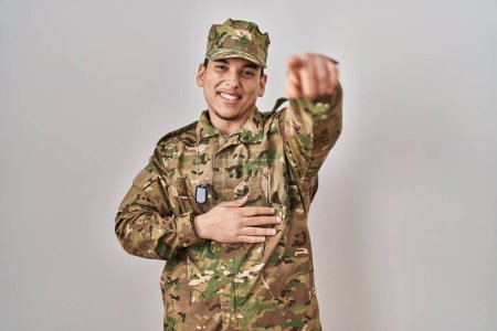 Téléchargez les photos : Jeune homme arabe portant un uniforme de camouflage de l'armée se moquant de vous, pointant du doigt la caméra avec la main sur le corps, expression de honte - en image libre de droit