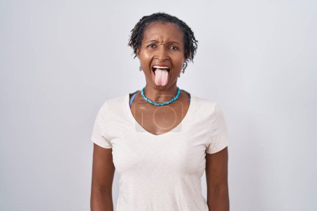 Photo for African woman with dreadlocks standing over white background sticking tongue out happy with funny expression. emotion concept. - Royalty Free Image