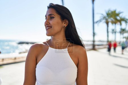 Photo for Young hispanic woman smiling confident walking at seaside - Royalty Free Image