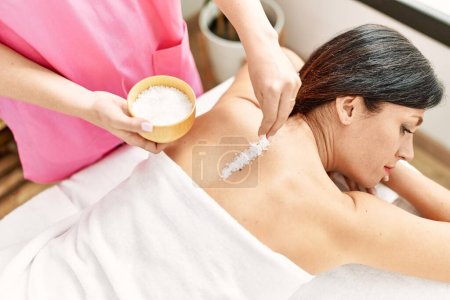 Téléchargez les photos : Moyen Age hispanique femme ayant sel massage dos au centre de beauté - en image libre de droit