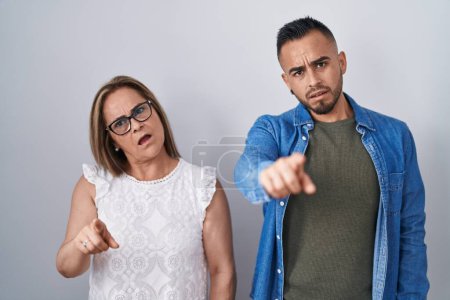 Photo for Hispanic mother and son standing together pointing displeased and frustrated to the camera, angry and furious with you - Royalty Free Image