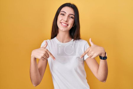 Photo for Young beautiful woman standing over yellow background looking confident with smile on face, pointing oneself with fingers proud and happy. - Royalty Free Image