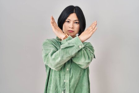 Photo for Young asian woman standing over white background rejection expression crossing arms doing negative sign, angry face - Royalty Free Image
