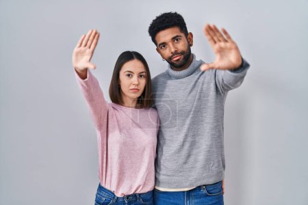 Photo for Young hispanic couple standing together doing frame using hands palms and fingers, camera perspective - Royalty Free Image