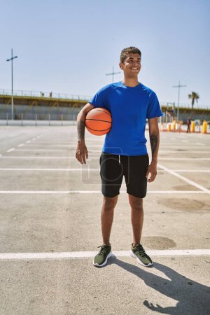 Photo for Young hispanic man training with basketball ball outdoors - Royalty Free Image