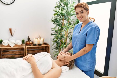 Téléchargez les photos : Woman couple smiling confident having facial massage at beauty center - en image libre de droit