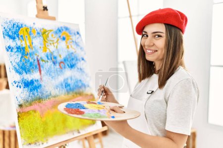 Photo for Young hispanic artist woman wearing french beret drawing at art studio. - Royalty Free Image