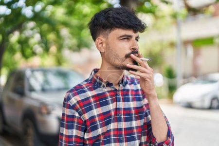 Foto de Young hispanic man smoking at street - Imagen libre de derechos